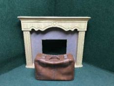A light oak fire surround and a leather suit case