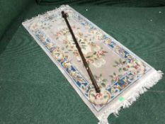 A fringed embossed Chinese rug and curtain rail