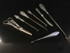 Four silver handled button hooks, scissors,