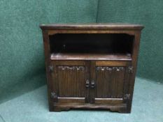 An oak linen fold double door cupboard