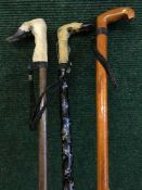A pair of two deer hoof handled walking sticks and one other