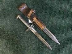 A WWII bayonet in steel scabbard on leather belt hanger