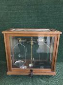 A set of jeweler's scales in a glass case