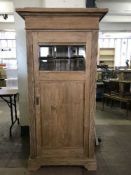 A pitch pine cabinet with glazed panel door