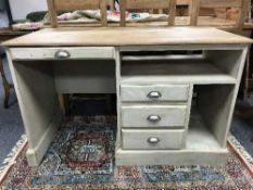 A reclaimed painted pine desk with cast metal handles