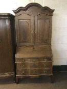An oak serpentine front bureau bookcase