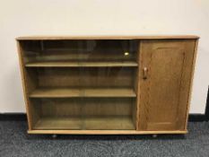 An Ercol elm sliding door bookcase