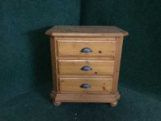 A pine three drawer bedside chest