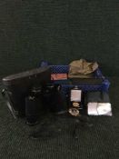 A basket of binoculars, stamp album, autograph books, AA badge, WW II medal,