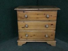 A pine three drawer chest
