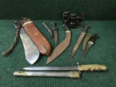 A kukri, a machete in sheath, a Japanese style dagger,