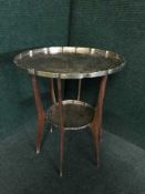 A mid 20th century teak table with brass trays