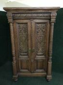 A late Victorian carved oak double door cupboard