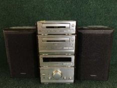 A Technics four piece separates system with speakers and remote and a crate of CDs and an extension
