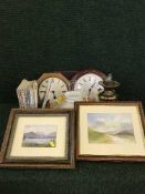 A box of wall clocks, brass oil lamp, flat iron, paperweights,