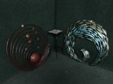 A tiled topped metal plant stand and two pieces of metal wall art
