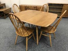 An Ercol elm drop leaf dining table and four spindle backed chairs