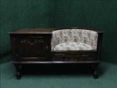 A carved oak telephone table