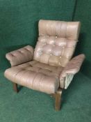 A mid 20th century brown button leather armchair and stool