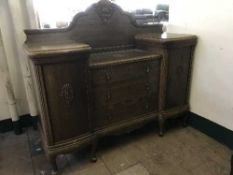 An early 20th century carved oak sunk centre sideboard