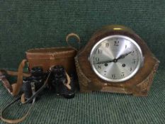 An oak cased Northern Goldsmiths mantel clock and a set of Dollond binoculars in leather case