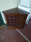 An oak low corner cabinet