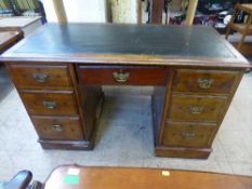 A late Victorian mahogany leather topped desk fitted with seven drawers