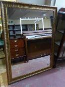 A large gilt framed bevelled overmantel mirror