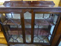 A mahogany double door display cabinet on claw and ball feet