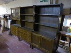 A triple section oak bookcase display cabinet fitted with cupboards and drawers beneath