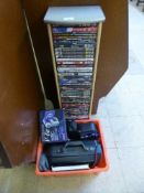 A dvd tower containing a quantity of dvds, together with a box of cameras,