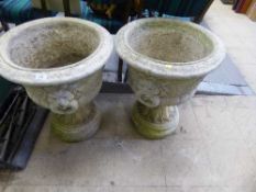 A pair of garden lion mask planters on stands