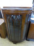 A walnut d-shaped display cabinet