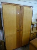 A five piece Butilux mid twentieth century teak bedroom suite comprising of two double wardrobes,
