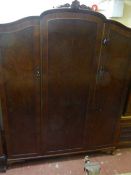 A walnut Queen Ann style triple door wardrobe