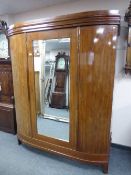A continental mahogany bowfront mirror door wardrobe