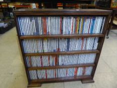 A set of walnut shelves containing a large quantity of cds,