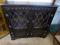 A carved oak leaded glass door bookcase