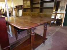 A Victorian mahogany flap sided table on reeded legs