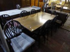 An oak refectory dining table together with six wheel backed chairs