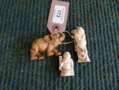 A carved hardwood netsuke of an elephant and two other bone netsukes