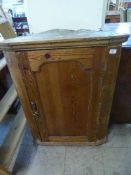 An antique pine hanging corner cabinet