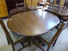 A circular oak extending pedestal table and four chairs