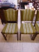 A set of four continental oak dining chairs upholstered in green striped fabric