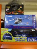 A remote controlled Subaru Impreza together with a boxed remote controlled helicopter and two cycle