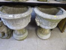 A pair of garden lion mask planters on stands