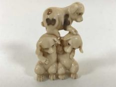 An early 20th century Japanese ivory netsuke, modelled as a group of three puppies,