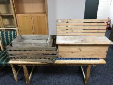 A small pine storage seat and five rustic wooden trays
