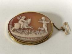 A yellow metal mounted cameo brooch depicting cherubs