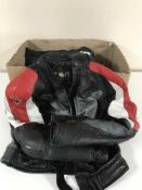 A box of motor cycle leathers with boots and gloves